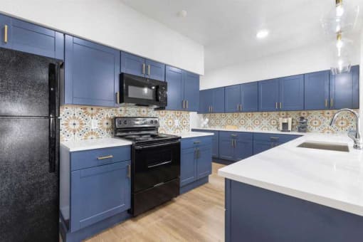 a kitchen with blue cabinets and a stove and a microwave