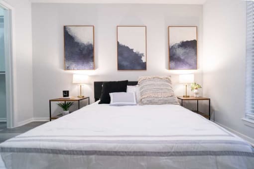 a bedroom with a bed and paintings on the wall