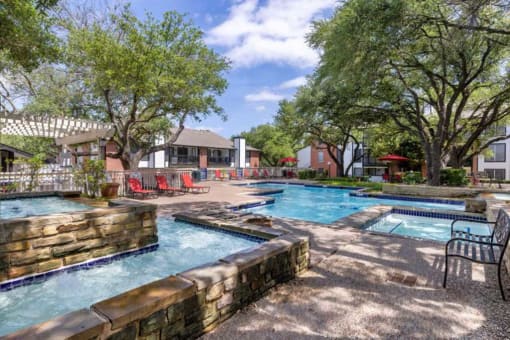 our apartments have a large pool with chairs and trees