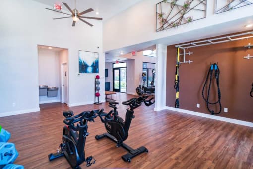 a home gym with exercise bikes and a ceiling fan
