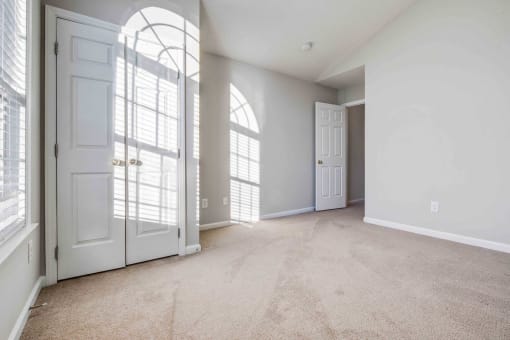an empty living room with white doors and white walls