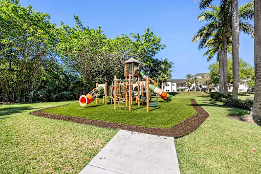 A playground with a wooden structure and a red slide.