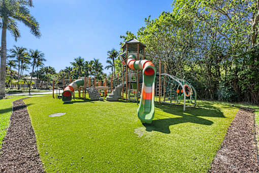 A playground with a green slide and a red and white slide.
