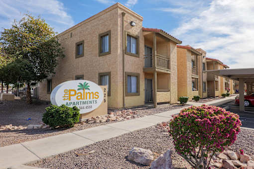 A building with a sign that says Palms Apartments.