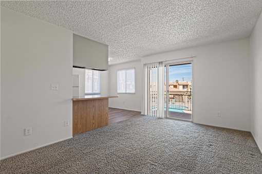 A room with a carpeted floor and a balcony with a railing.