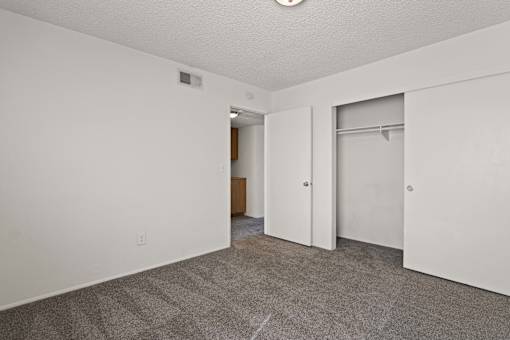 A room with a carpeted floor and a white door.
