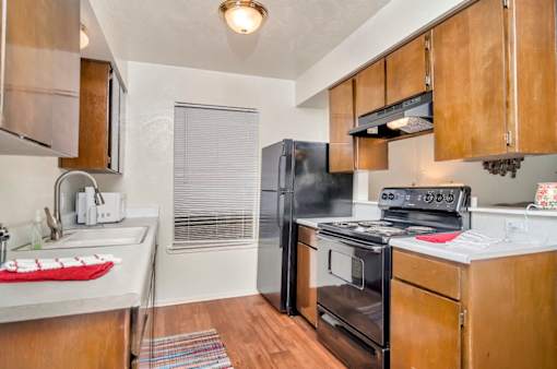 A kitchen with a black refrigerator, stove, and oven.