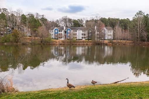 two standing next to a lake in front of a building