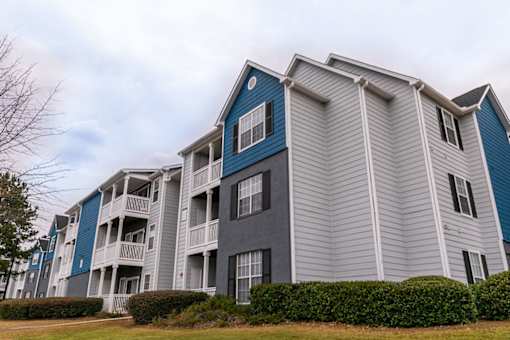 a group of apartment buildings with blue and gray siding