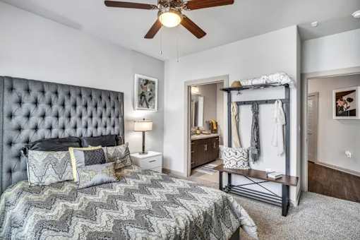 A bedroom with a large bed and a ceiling fan.