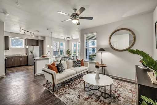 A living room with a white couch and a rug.