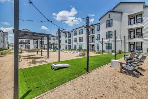 A sunny day at a modern apartment complex with a sandy courtyard.