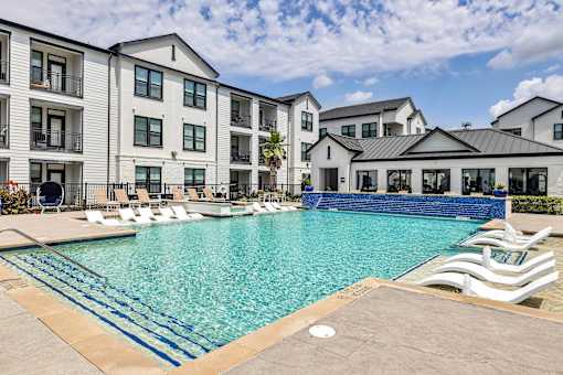 A large swimming pool in front of apartment buildings.