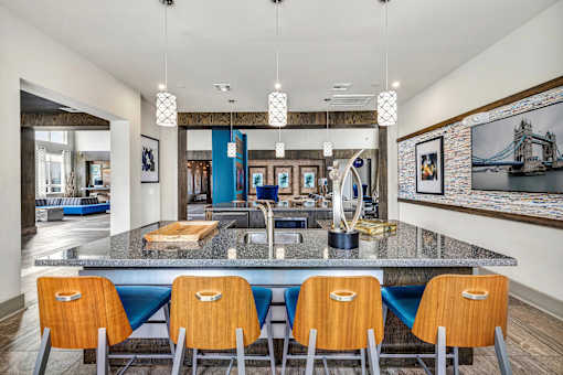A kitchen with a large island and blue chairs.