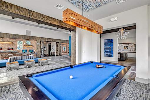 A pool table is in the middle of a room with a blue carpet.