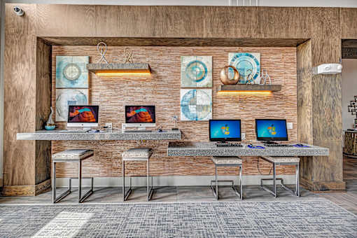 A modern office space with a wooden wall and two computers on a desk.