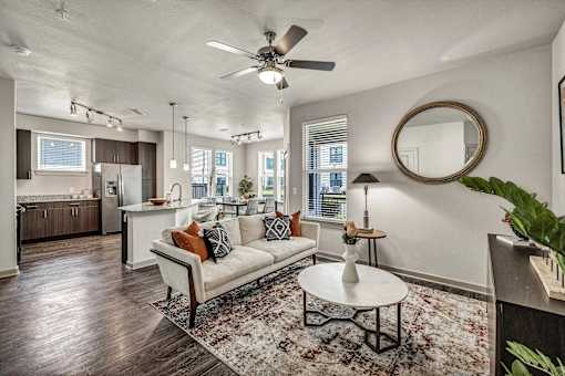 A living room with a white couch and a rug.