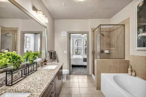 A bathroom with a tub, sink, and mirror.
