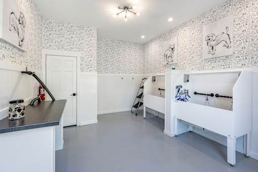 A white room with a black counter and a white bed.