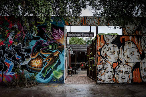 A graffiti covered wall with a sign that says "barcelona" above it.