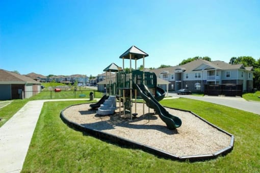 a playground with slides in a neighborhood with houses