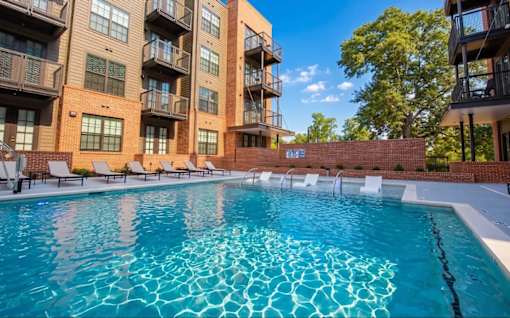 A swimming pool in front of apartment buildings.