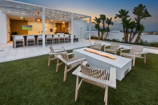 a patio with tables and chairs and a fire pit
