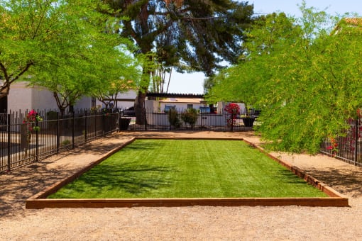 a backyard with a grassy area and a black fence