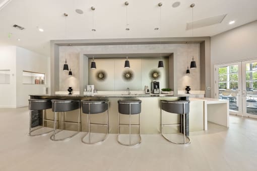 a kitchen with bar stools in front of a large mirror