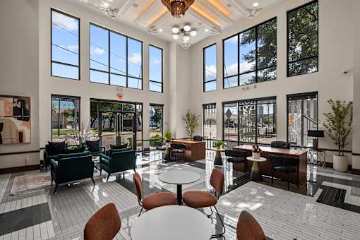 A large room with tables and chairs and a lot of windows.