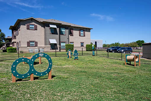 A green sign with two circles on it is in front of a building.
