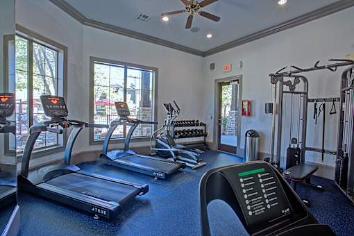 A gym with treadmills, elliptical machines, and other exercise equipment.