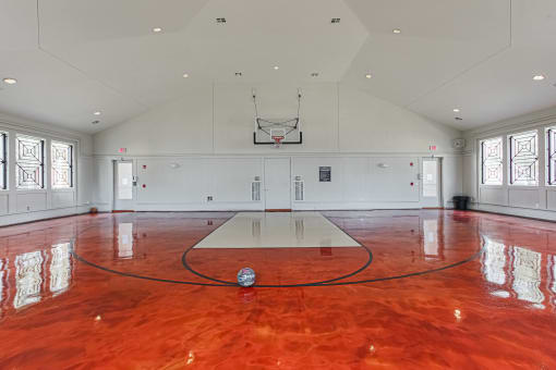 a basketball court in the center of a large room with windows