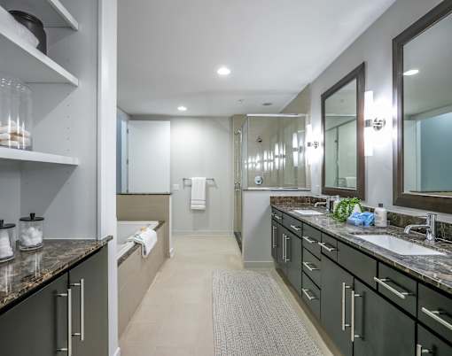 A bathroom with a sink, mirror, and a towel hanging on the wall.