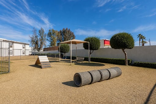 A playground with a slide, a swing set, and a few trees.