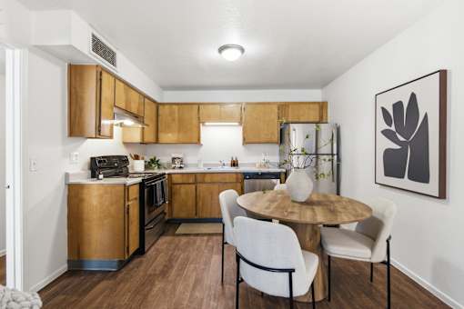 A kitchen with a table and chairs.