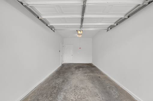 A white room with a door and a light hanging from the ceiling.