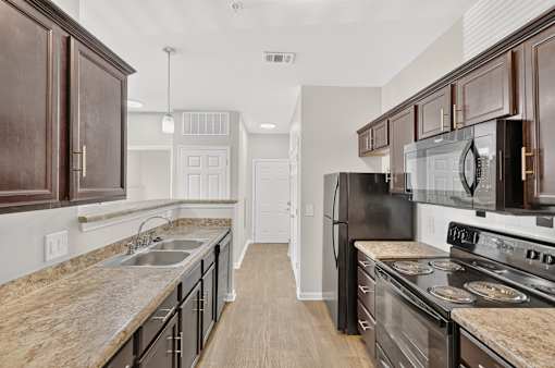 A kitchen with black appliances and wooden cabinets.