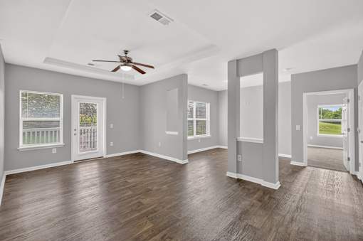 A spacious room with a ceiling fan and sliding glass doors.