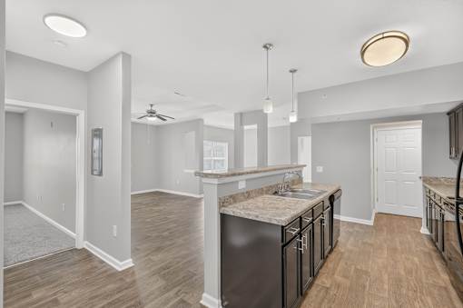 A kitchen with a marble countertop and a fan on the ceiling.