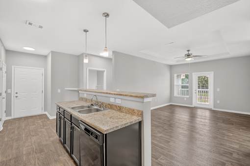 A kitchen with a sink, stove, and countertop.