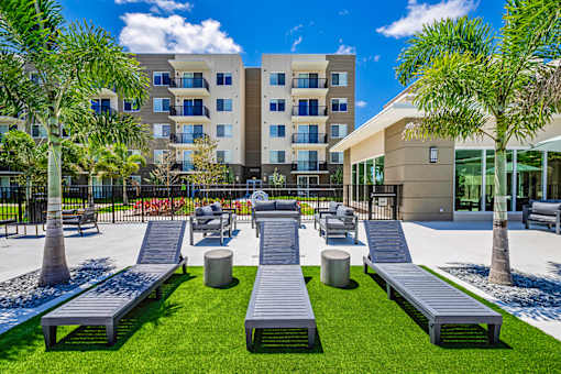 A modern building with a grassy area in front and benches for seating.