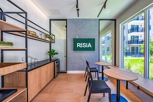 A modern office space with a wooden floor and a green plant on the shelf.