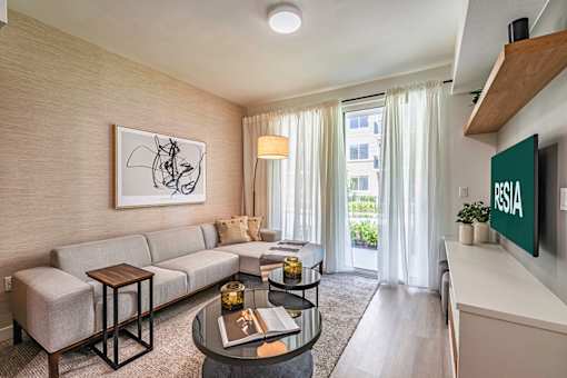 A living room with a sofa, a coffee table, and a painting on the wall.