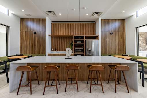 A modern kitchen with a long island and bar stools.