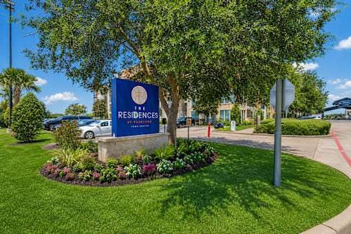 A sign for The Residences at the entrance to a gated community.