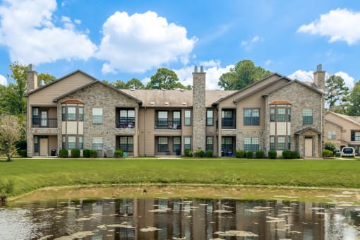 a large building with a pond in front of it