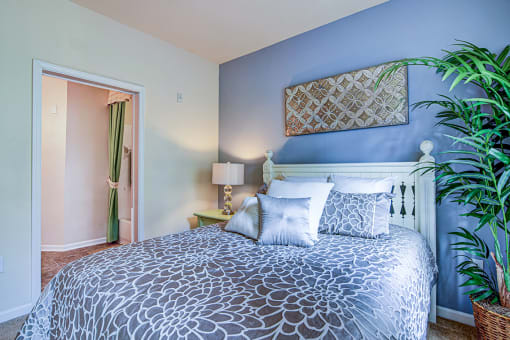 A bedroom with a patterned bedspread and a white bed.