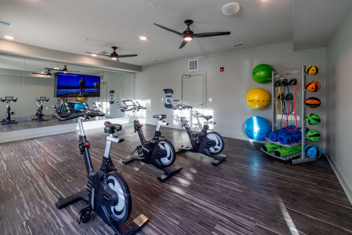 a gym with exercise equipment and a tv