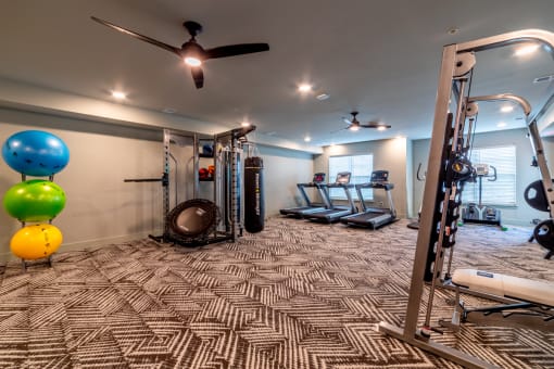 create a home gym with plenty of exercise equipment and a ceiling fan